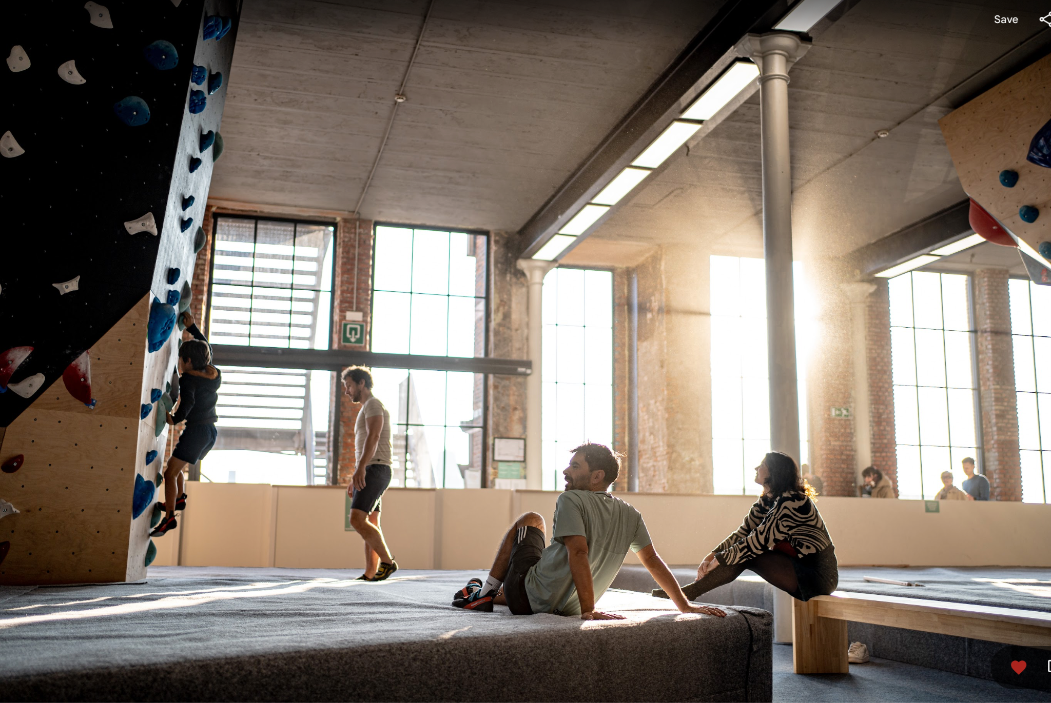 Bouldering kinderen Walden Gent: Jeugdige klimmer op de bouldermuur van Walden Gent, onder het oog van volwassenen, in de lichtrijke klimzaal.