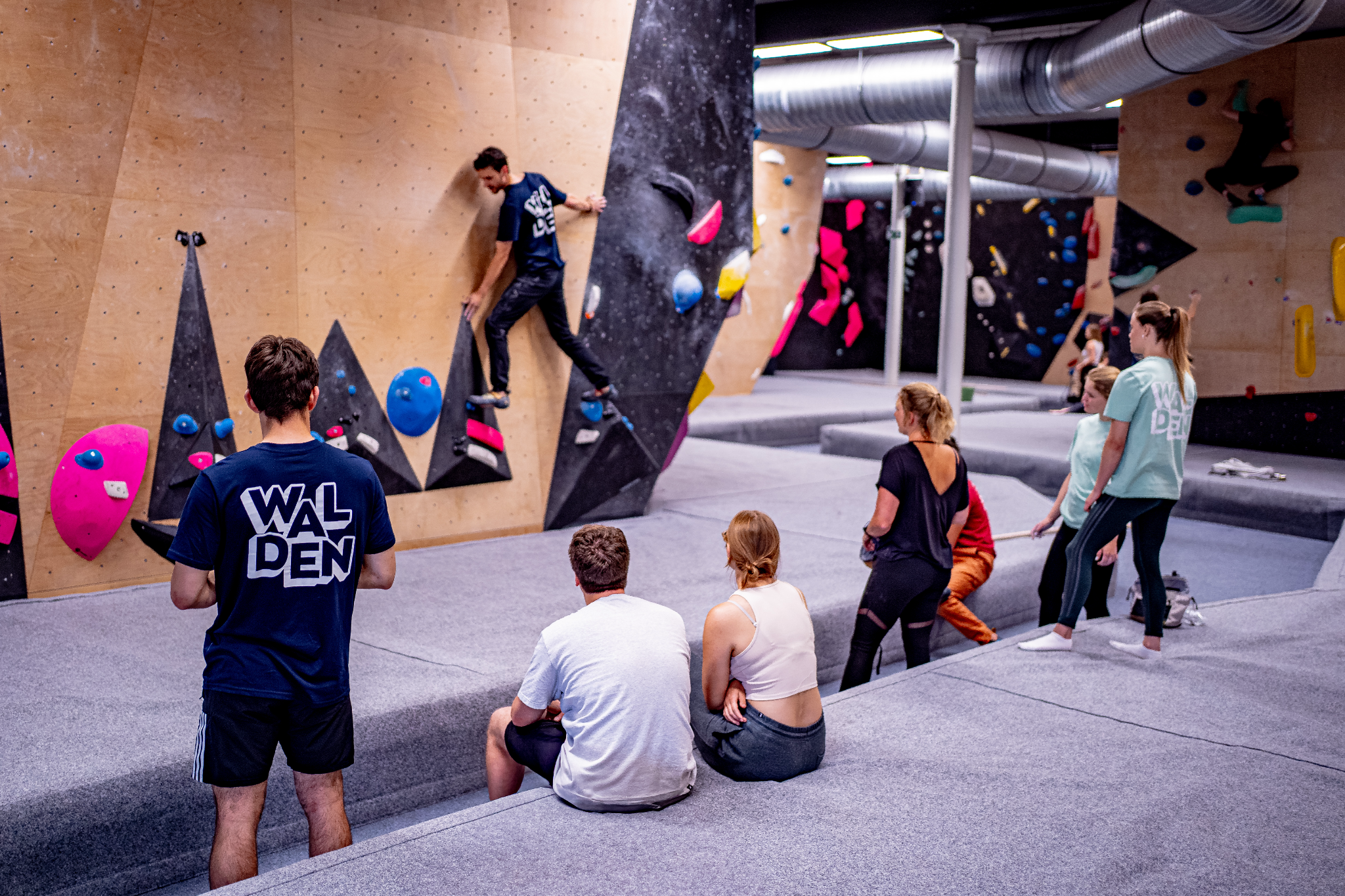 Walden Gent groepen Groepsactiviteit in de boulderhal met klimmer op de wand en toeschouwers op de mat
